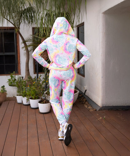 A person wearing the Multicolour Neon Jacket & Joggers Set with cargo pockets stands on a wooden deck facing away, near potted plants.