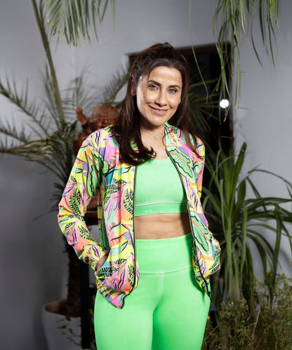 A woman in a colorful jacket and neon green leggings.