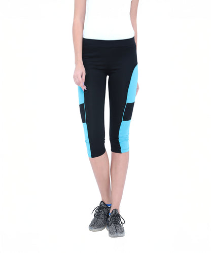 Woman wearing Capri TLC66 black and blue cotton spandex capri workout pants, a white top, and grey sneakers, standing against a white background.