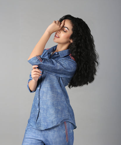 A woman with long curly hair poses in a relaxed fit Denim Linen Co-Ord Set, touching her forehead.
