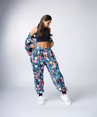 Woman in the Tuna Active Floral Co-ord Set, paired with a black crop top and white sneakers, standing against a plain background.