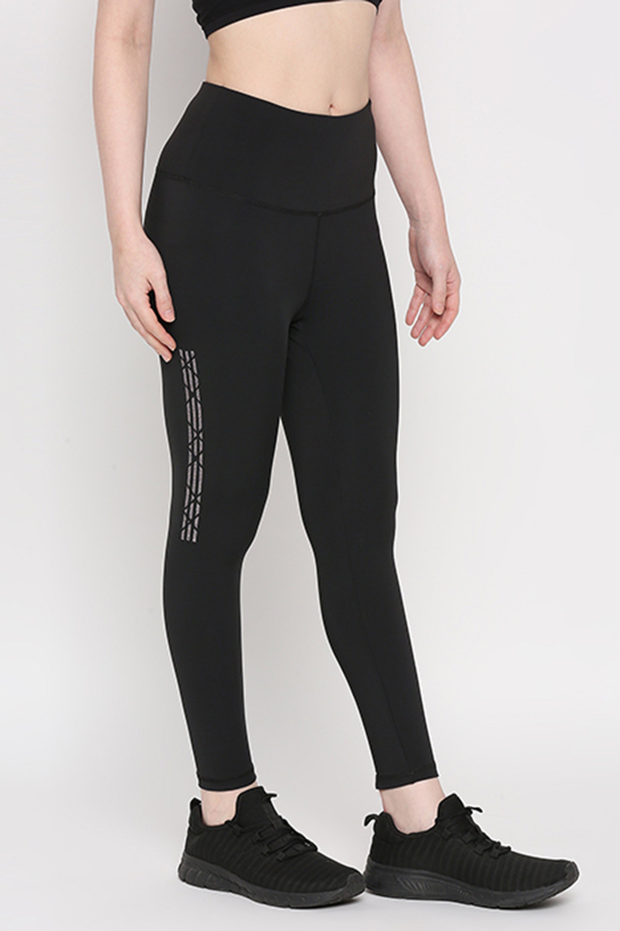 Person wearing Tuna Active Black Leggings With Print and black sneakers, standing against a plain white background—ideal for yoga, gym, sports, or fitness routines.