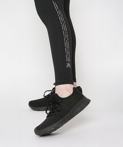 Person wearing Tuna Active Black Leggings With Print and black athletic shoes, standing on a white floor.