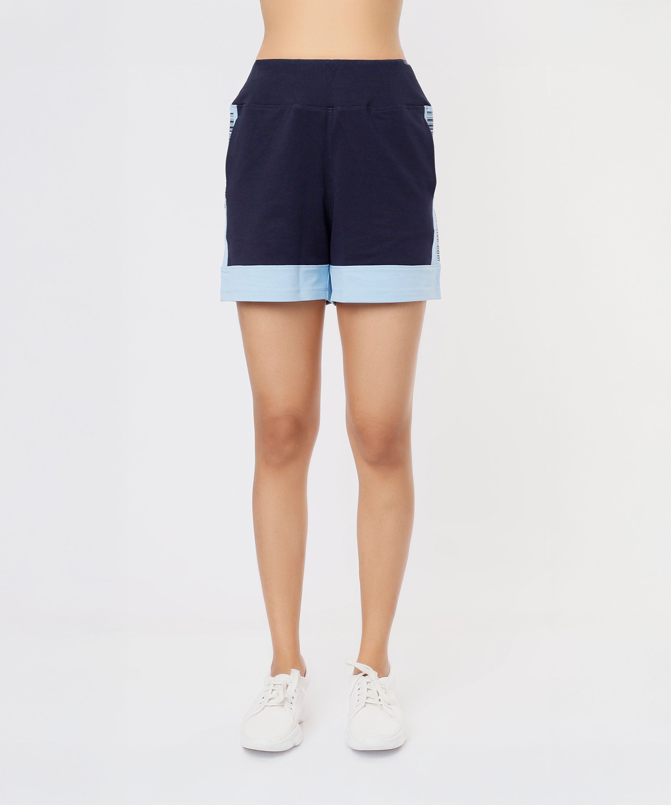 A person wearing a Tuna Active Blue Tee with navy blue cotton lycra shorts, light blue cuffs, and white sneakers, standing against a white background.
