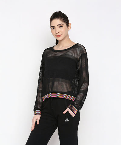 A woman wears the Black Netted Top with black pants, posing against a plain white background for a sporty look.