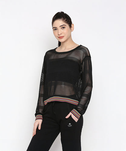 A woman wears the Black Netted Top with black pants, posing against a plain white background for a sporty look.