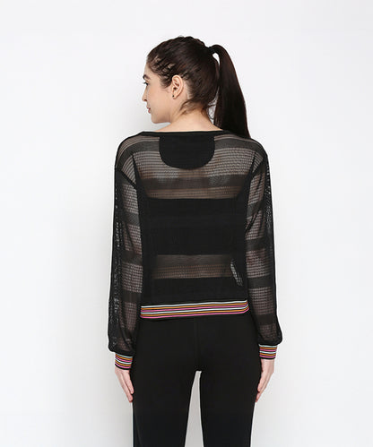 A woman shown from behind wears a sporty Black Netted Top with striped cuffs and waistband, paired with black polyblend pants.
