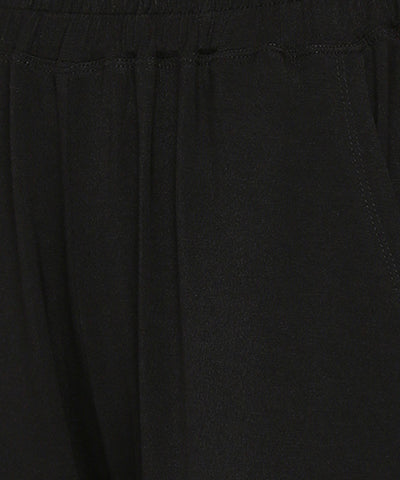 Close-up of the Comfy Black Set with Side Sparkle showing its black, loose fit track pant fabric, elastic waistband, and visible stitching by the pocket.