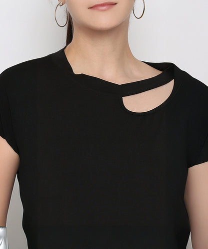 A woman wears the Versatile Black Ensemble, a buttery soft top featuring a neck cut-out and asymmetrical neckline, paired with large hoop earrings.