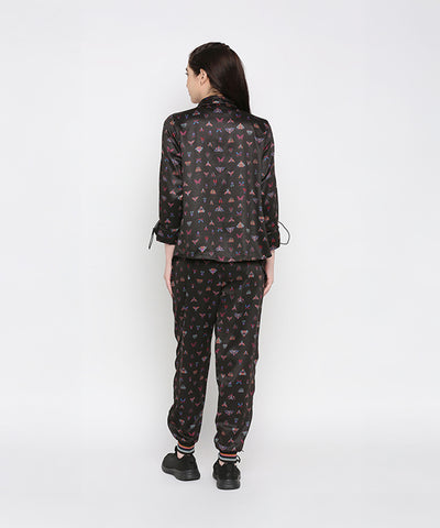 A woman stands with her back to the camera, wearing the Tuna Active Butterfly Joggers with a matching black printed top.