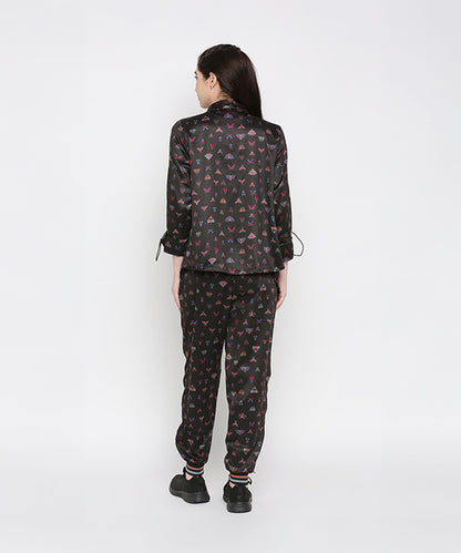 A woman stands with her back to the camera, wearing the Tuna Active Butterfly Joggers with a matching black printed top.