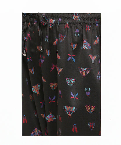 Tuna Active Butterfly Joggers: Black satin joggers with vibrant moth and butterfly prints, finished with a drawstring waistband—add a bold statement to your style with these unique, eye-catching joggers.