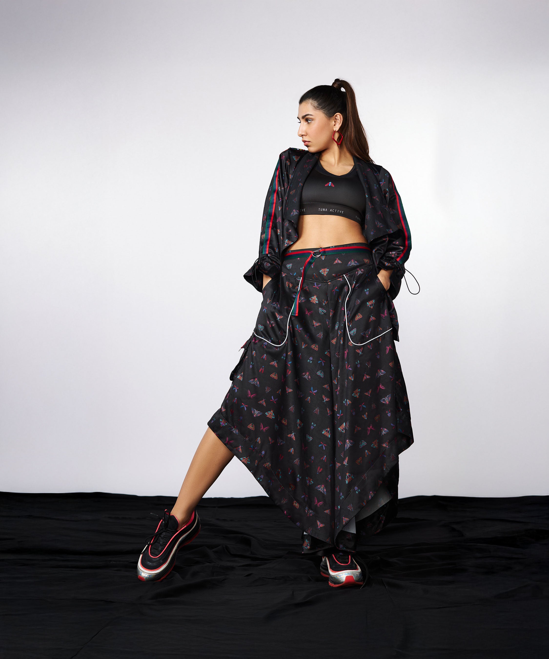 Woman wears the Tuna Active Co-ord Set—yoga pants and athleisure jacket—in black, featuring cargo pocket details, posing against a plain backdrop.