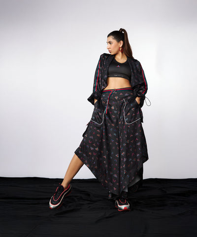Woman wears the Tuna Active Co-ord Set—yoga pants and athleisure jacket—in black, featuring cargo pocket details, posing against a plain backdrop.
