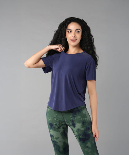 Woman with long curly hair wears the Functional - Blue Soft T Shirt, made from durable, comfortable materials, posing against a gray background.