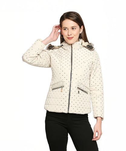 Woman wearing an Off White Mid Length High Collar Puffer Jacket With Detachable Fur Hoodie, paired with black pants, touching her hair and standing against a white background.