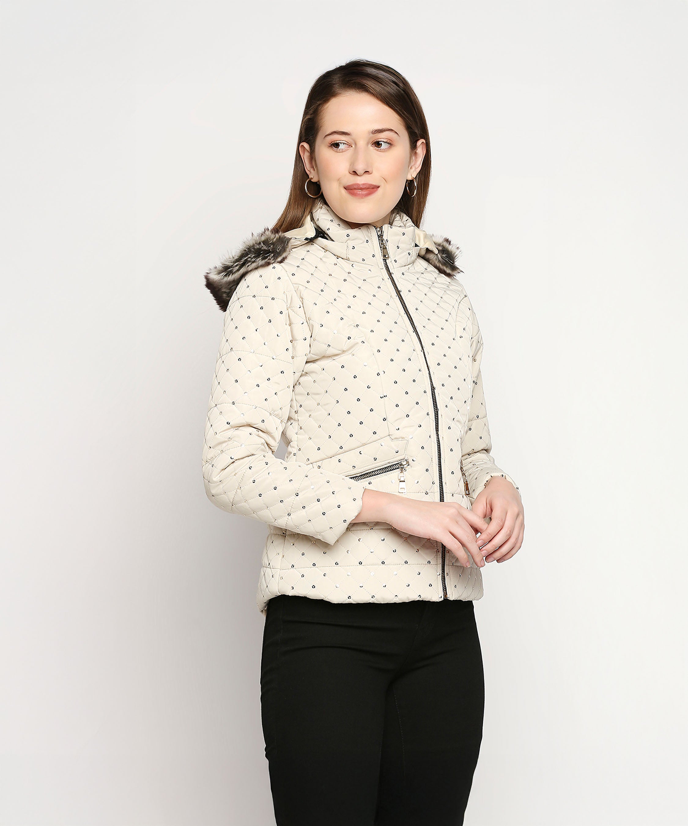 A woman models the Off White Mid Length High Collar Puffer Jacket with Detachable Fur Hoodie and black pants against a plain white background, highlighting this stylish and cozy winter essential for women.