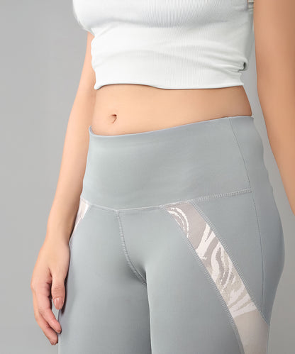 Woman in a Grey Top with Patched Legging, featuring moisture-wicking fabric to keep you cool while showing off your midriff.