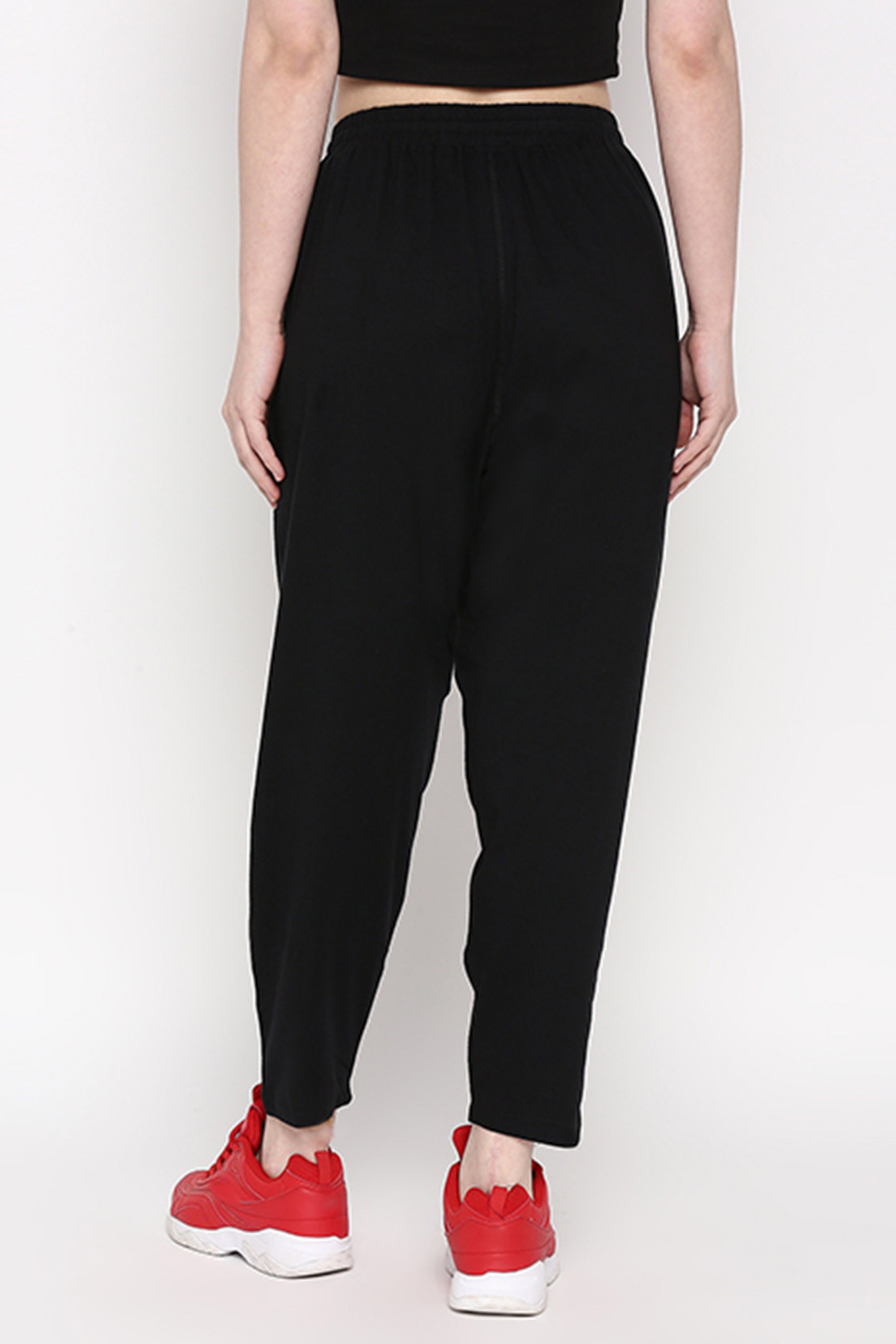 Person wearing Yoga Pants and red sneakers, standing with their back to the camera against a plain white background.