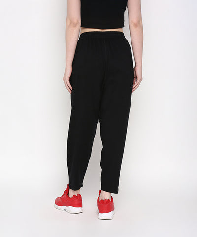A person wearing Yoga Pants, shown from the back with red sneakers, stands against a plain white background.