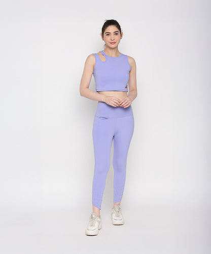 A woman models the Tuna Active Lavender Co-ord Set, featuring a lavender crop top and matching leggings, paired with white sneakers, as she stands confidently against a plain white background.