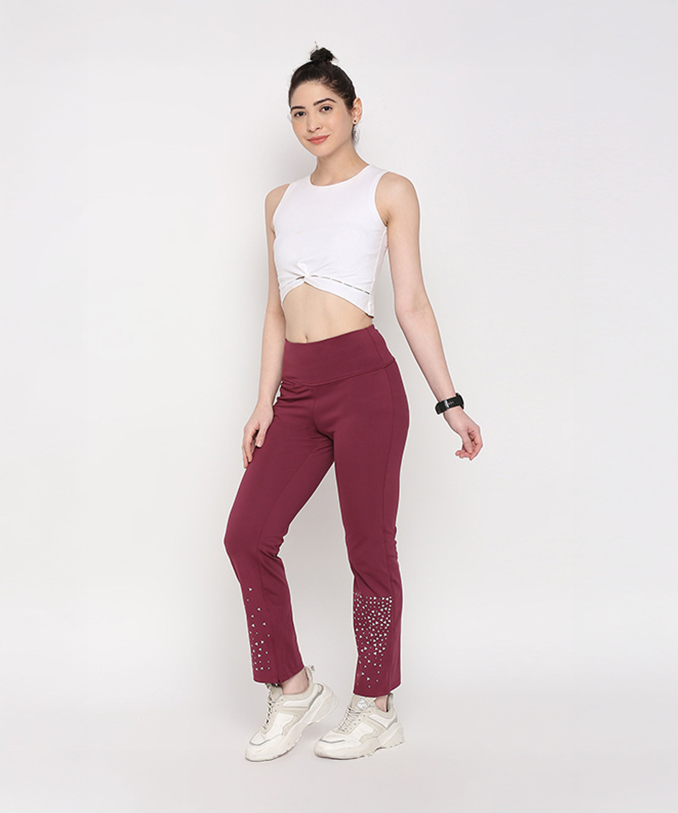 Woman in a white crop top and Tuna Active Wine Color Boot Cut Pants, posing against a plain white background.