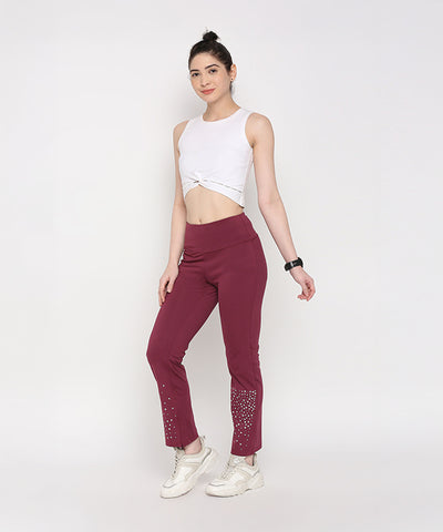 Woman in a white crop top and Tuna Active Wine Color Boot Cut Pants, posing against a plain white background.