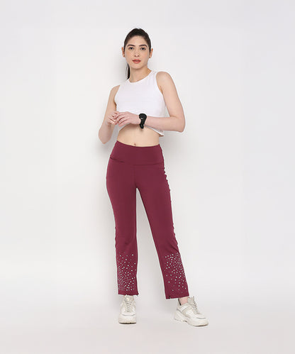 A woman in a White Twisted Crop Top, maroon pants, and white sneakers stands against a plain white background.