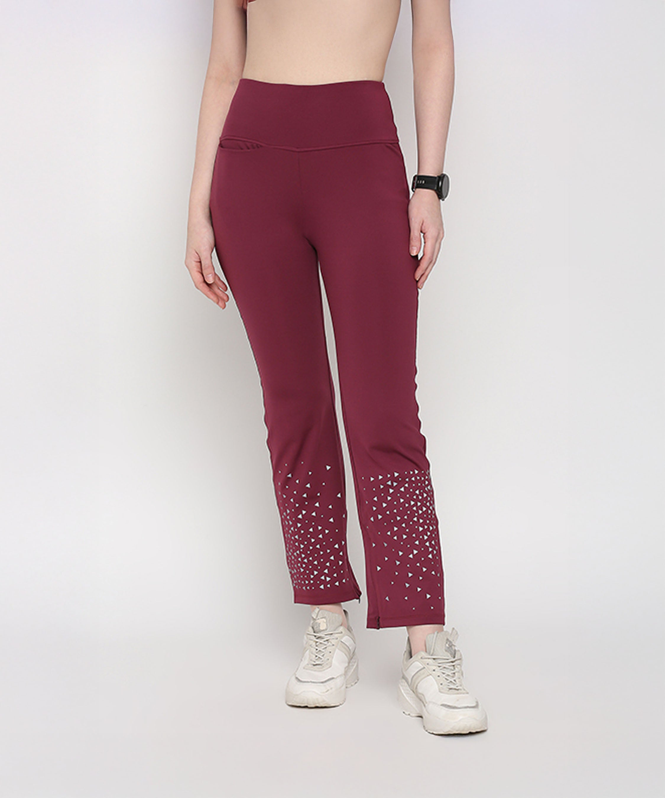 Woman wearing Tuna Active Wine Color Boot Cut Pants with white sneakers and a black watch.