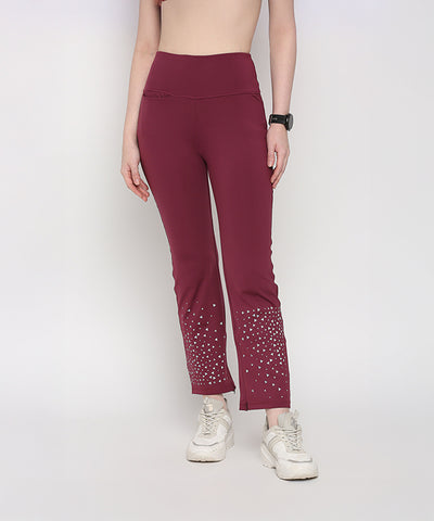 Woman wearing Tuna Active Wine Color Boot Cut Pants with white sneakers and a black watch.