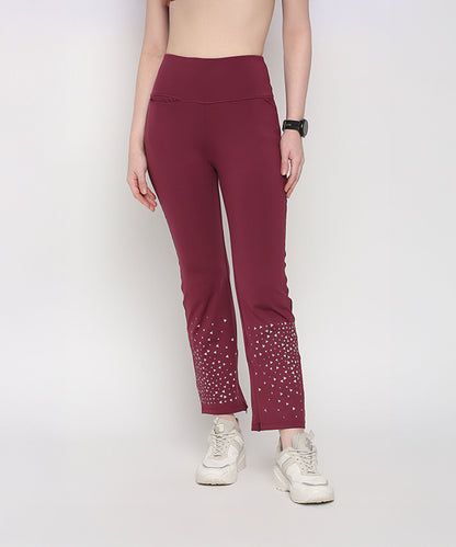 Woman wearing Tuna Active Wine Color Boot Cut Pants with white sneakers and a black watch.