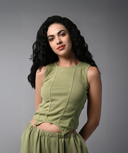 Woman with long curly black hair wears the Olive Corset Crop - Top with Parachute Pants, standing against a gray background.