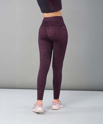 Model faces away from the camera, wearing Pink Animal Print Leggings and sneakers against a plain gray background.