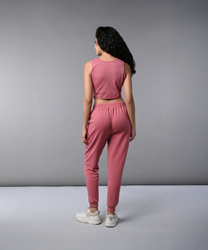 Woman with long dark hair wearing a Pink Corset Crop-Top with Joggers co-ord set, featuring a sleeveless top and joggers, facing away in white sneakers.