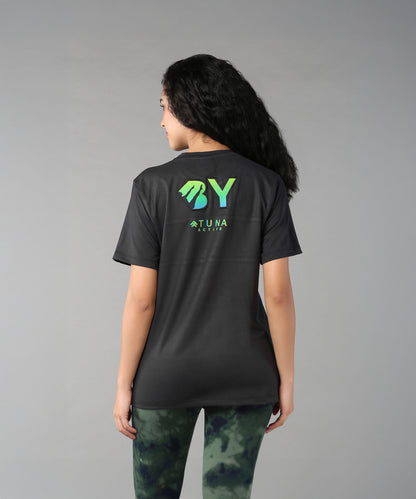 A woman with long curly hair, seen from behind, wears the Positive Body Image T Shirt—a black basic tee with green text and half sleeves—embracing positive body image.