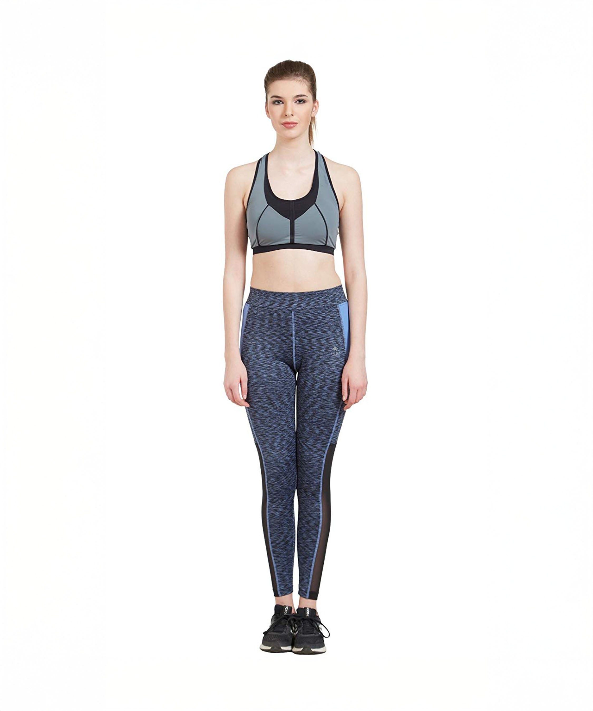 A woman in athletic wear stands facing forward on a white background, wearing a Blue Poly Cotton Lycra Printed Slim Fit Track Pant for Women.