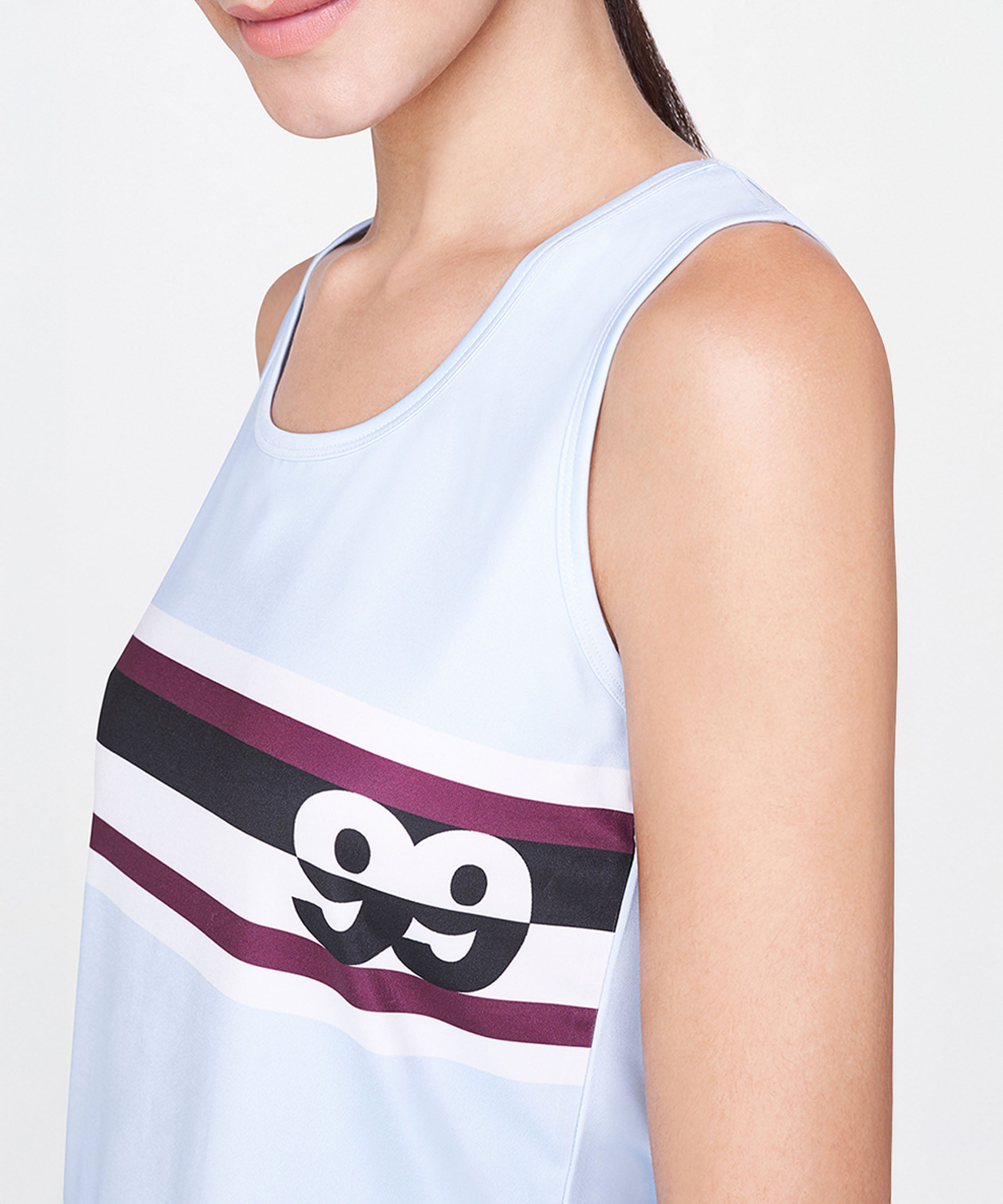 Woman wearing a relaxed fit Powder Blue T-Shirt featuring maroon and black stripes, sleeveless design, and an eyes graphic.