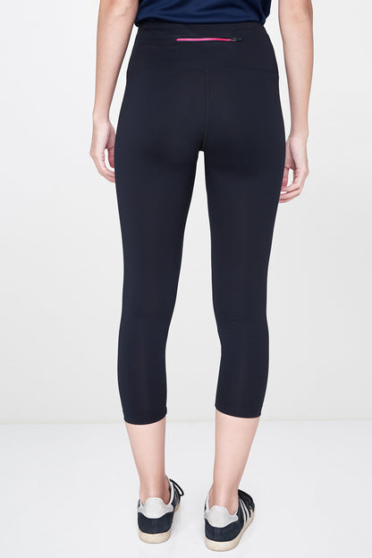 Someone is seen from the back wearing Black Leggings and classic white sneakers against a plain background—an effortless wardrobe essential.