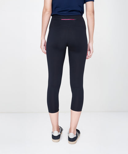 Person standing with their back to the camera, wearing Black Leggings featuring a high-rise waistband, paired with a navy shirt and sneakers.