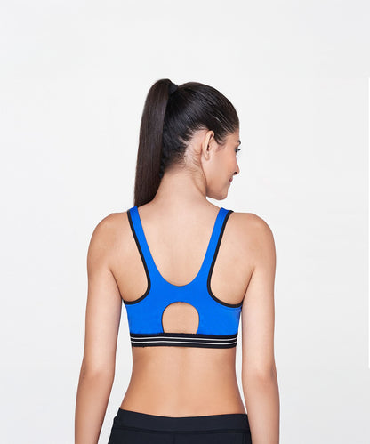 A woman with a long ponytail is seen from the back wearing the Blue Sports Bra and black leggings—a perfect, stylish activewear look.