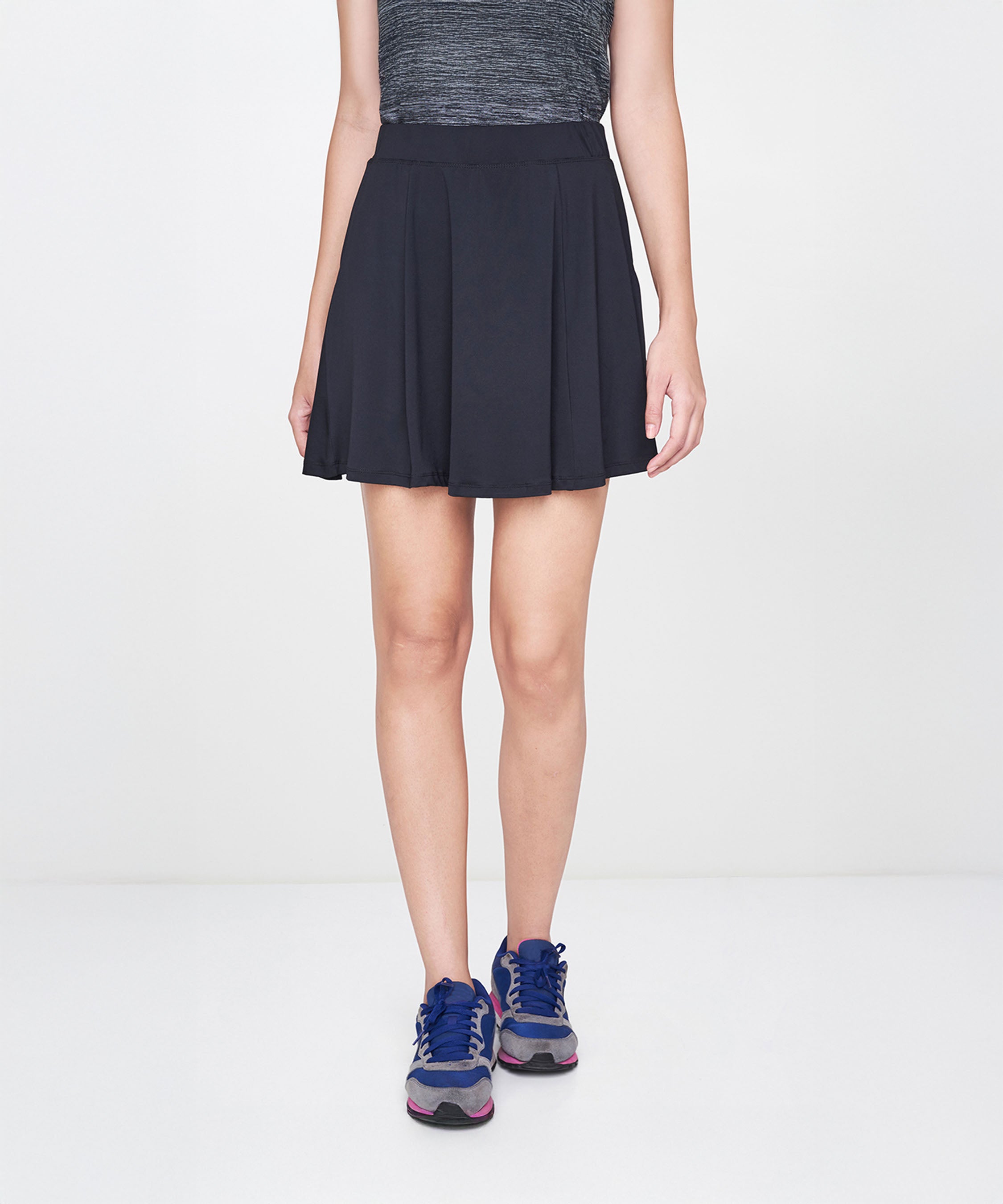 Person wearing a grey skirt, standing against a plain white background.