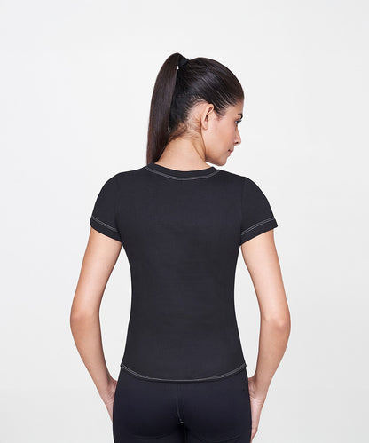 A woman with dark hair in a ponytail is seen from behind, wearing the Black T-Shirt—a fitted and timeless wardrobe staple.
