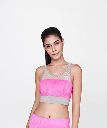 A woman wearing the Pink Sports Netted Bra stands against a plain white background.