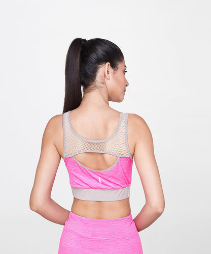 A woman with a ponytail wears the Pink Sports Netted Bra and matching leggings, activewear set, as she faces away from the camera.