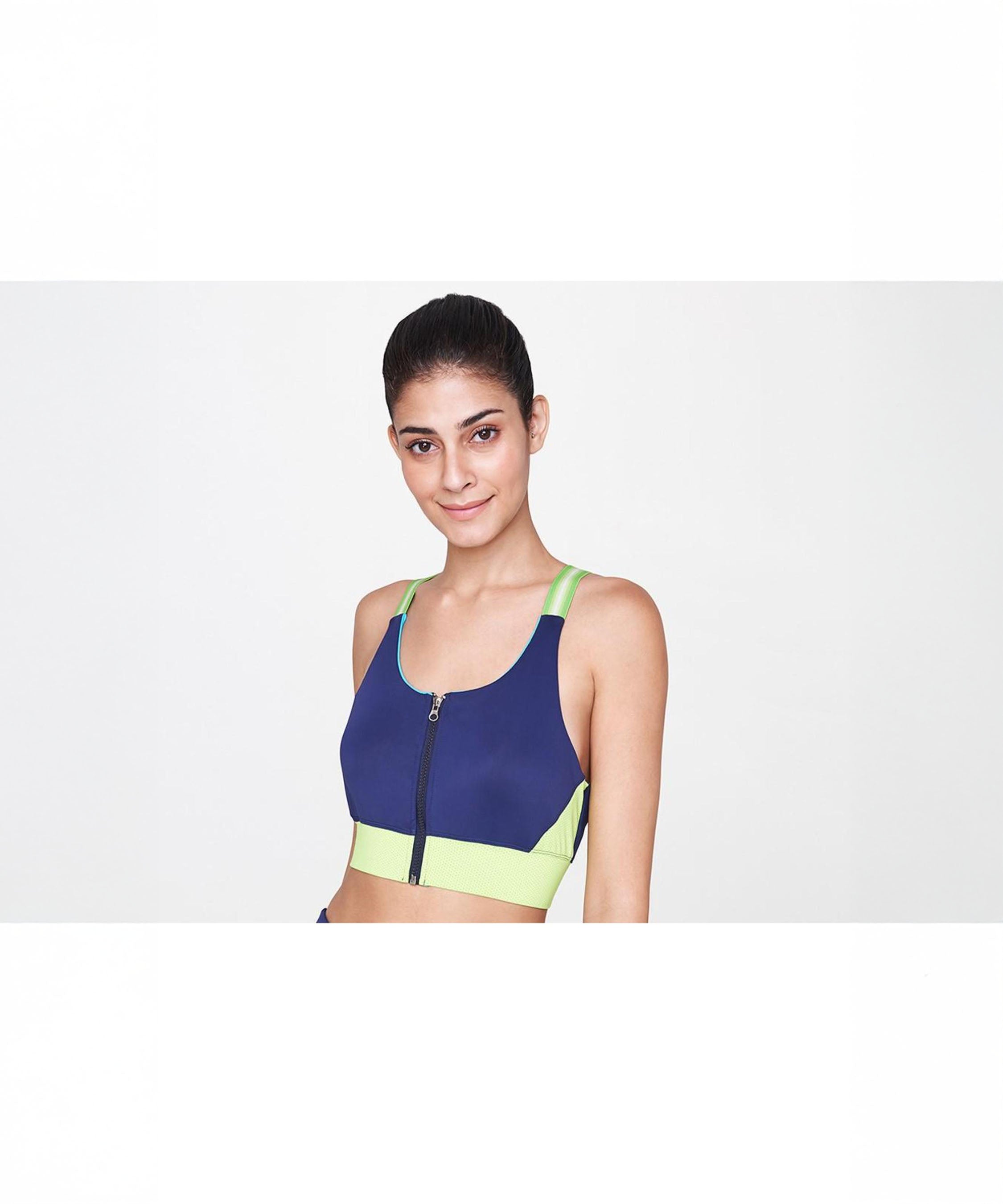 Woman wearing the Zipped Blue and Neon Bra, featuring a front zipper, stands against a white background.