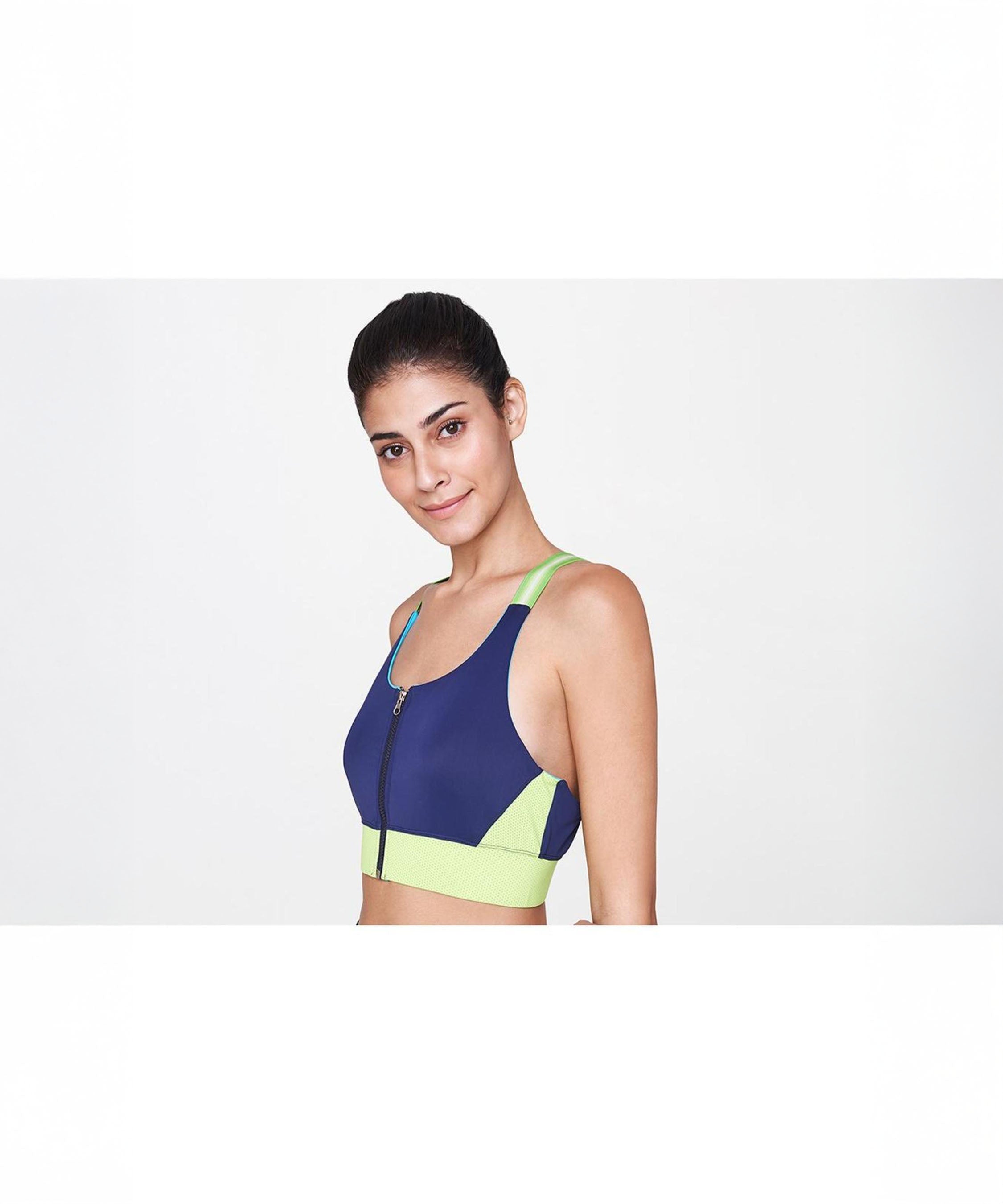 Model poses confidently in the Zipped Blue and Neon Bra, featuring a vibrant navy and neon green design—ideal for stylish activewear—against a plain white background.