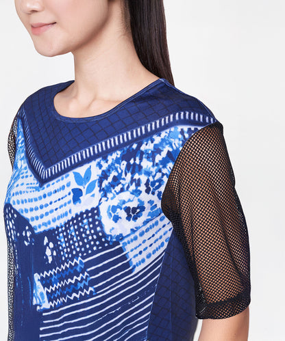 A woman wearing an Indigo Printed Top With Leggings featuring blue and white prints and net sleeves.