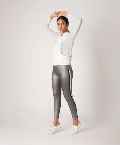 Woman in athletic wear poses with arms raised, wearing a white jacket and High Waisted Metallic Leggings TLC116.