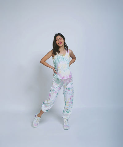 Woman wearing Comfort Fit Joggers and a Netted Tank Top, smiling and posing against a plain light background.