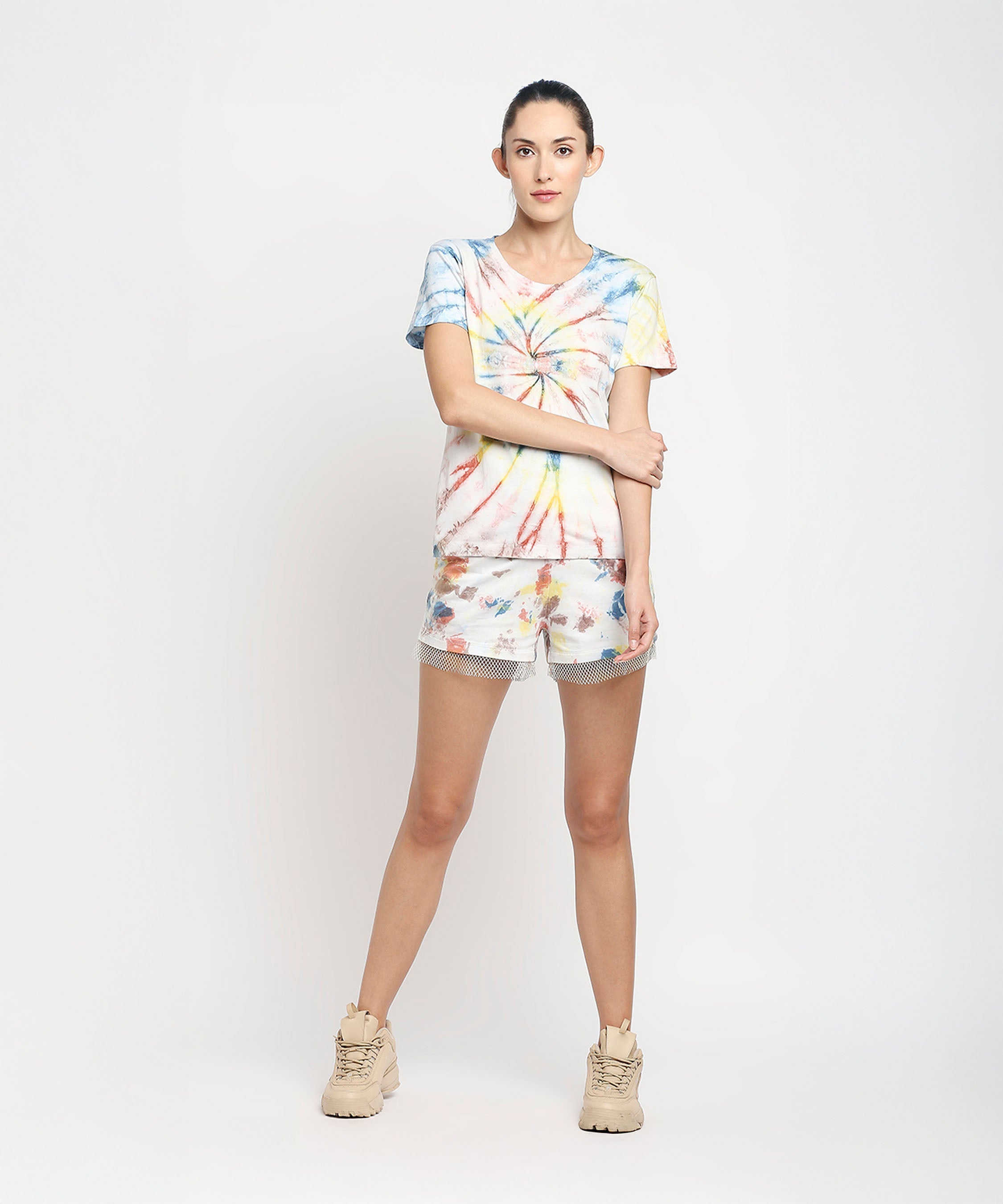 A woman wearing the Netted shorts + comfort tee stands against a plain white background, paired with beige sneakers.